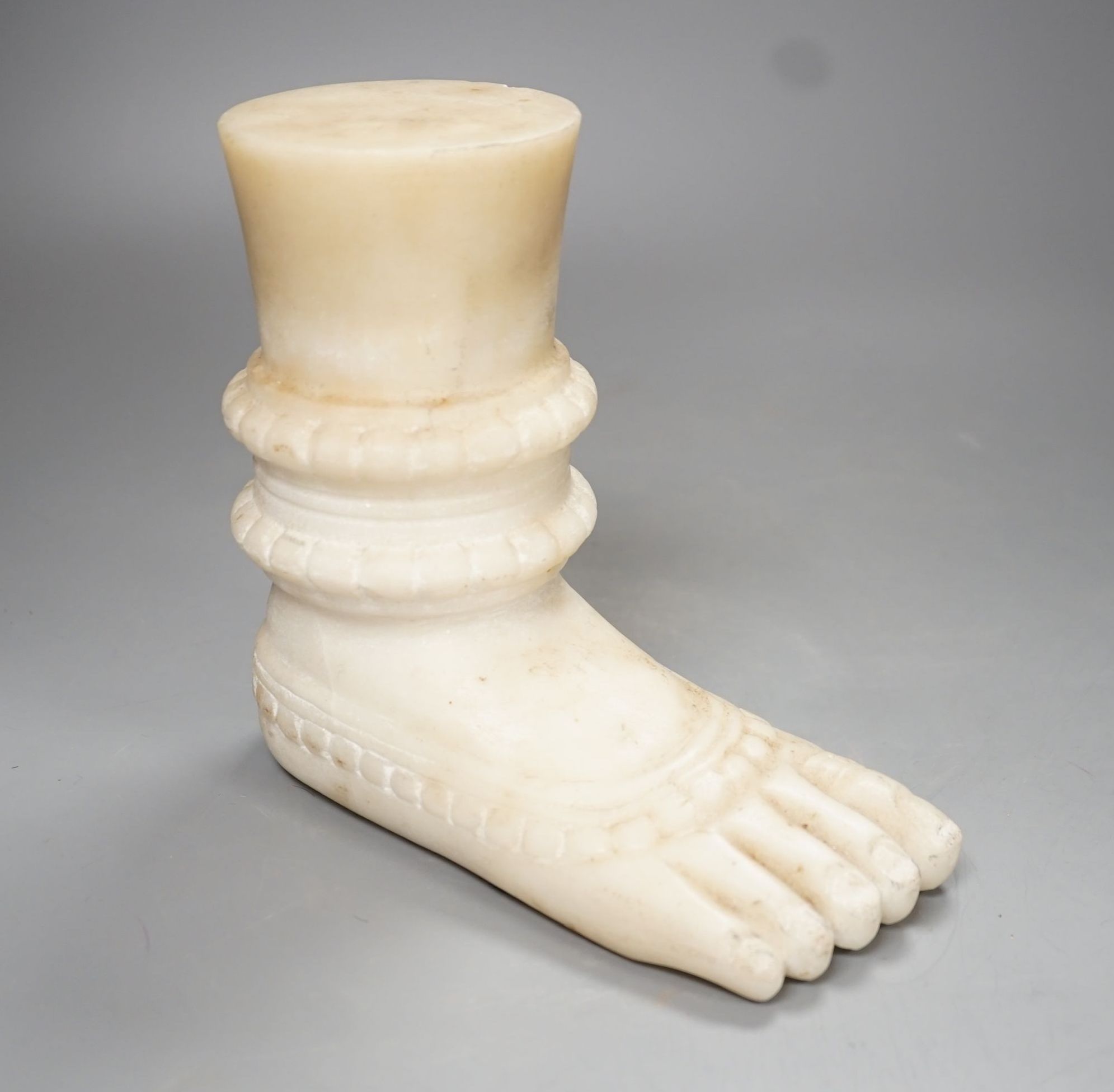 An Indian white marble foot of a deity - 18cm high